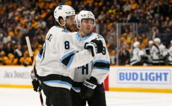14 de abril de 2025; Nashville, Tennessee, Estados Unidos; El centro del club de hockey de Utah, Nick Schmaltz (8) celebra el objetivo del centro Clayton Keller (9) contra los depredadores de Nashville durante el segundo período en Bridgestone Arena. Crédito obligatorio: Steve Roberts-Imagn Images