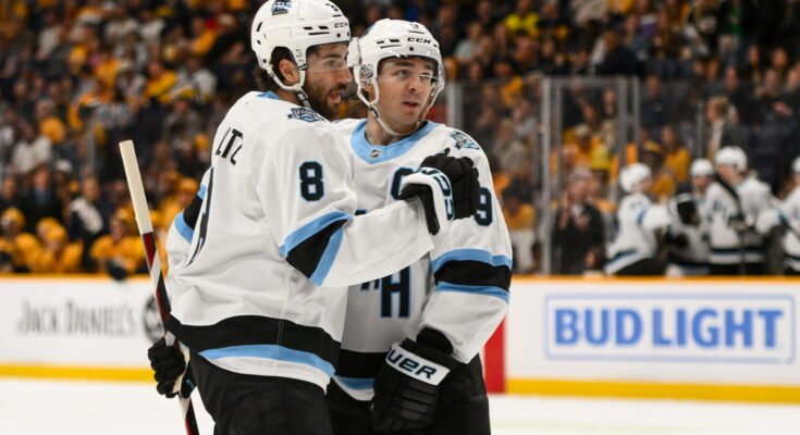 14 de abril de 2025; Nashville, Tennessee, Estados Unidos; El centro del club de hockey de Utah, Nick Schmaltz (8) celebra el objetivo del centro Clayton Keller (9) contra los depredadores de Nashville durante el segundo período en Bridgestone Arena. Crédito obligatorio: Steve Roberts-Imagn Images