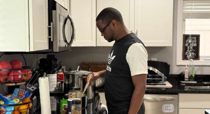 Samuel Kangethe cocina en su casa el 3 de julio de 2025 en Lansing, Michigan.