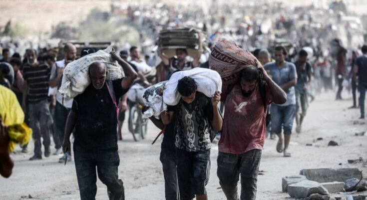 Los palestinos llevan bolsas y cajas en cartón plegado mientras regresan de un punto de distribución de alimentos dirigido por los Estados Unidos y la Fundación Humanitaria de Gaza con el sábado de los Estados Unidos, cerca del Corredor NetSarim en la Franja Central de Gaza.