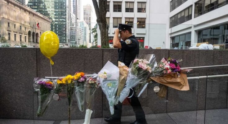 NUEVA YORK, Nueva York - 29 de julio: un oficial de policía de Nueva York pasa frente a flores colocadas frente al edificio de oficinas del centro de la ciudad, donde un hombre armado mató a cuatro personas el 29 de julio de 2025 en Nueva York. (Foto de Stephanie Keith / Getty Images)