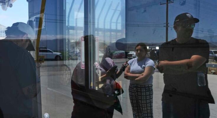 La gente espera afuera de Glass House Farms, un día después de una redada de inmigración en el establecimiento, el viernes 11 de julio de 2025, en Camallo, California.