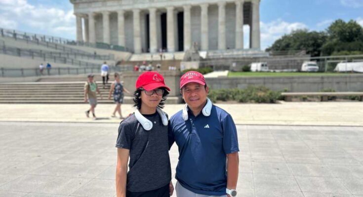 Jeffrey Pagulong (derecha) y su hijo de 12 años, Christof, se llevan a cabo cerca de Lincoln Memorial en Washington, DC, ambos usan gorras de béisbol rojas y ventiladores de enfriamiento de cuello blanco.