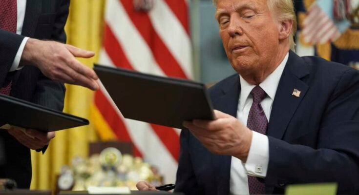 El presidente Donald Trump firma decretos en la Oficina Oval de la Casa Blanca el 20 de enero.