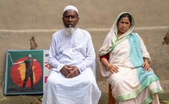 Los padres de Abu Sayed, Mokbul Hussein y Monowara Khatun, se sientan en el patio de su casa en Rangpur, Bangladesh, el 30 de julio. En la pared detrás de ellos, una placa conmemorativa dedicada a su hijo que fue asesinado por la policía durante las manifestaciones del año pasado.