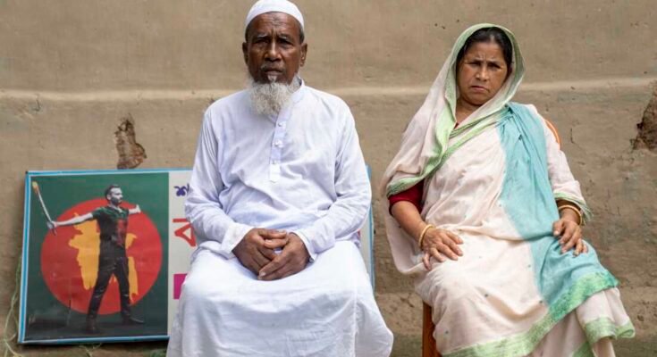 Los padres de Abu Sayed, Mokbul Hussein y Monowara Khatun, se sientan en el patio de su casa en Rangpur, Bangladesh, el 30 de julio. En la pared detrás de ellos, una placa conmemorativa dedicada a su hijo que fue asesinado por la policía durante las manifestaciones del año pasado.
