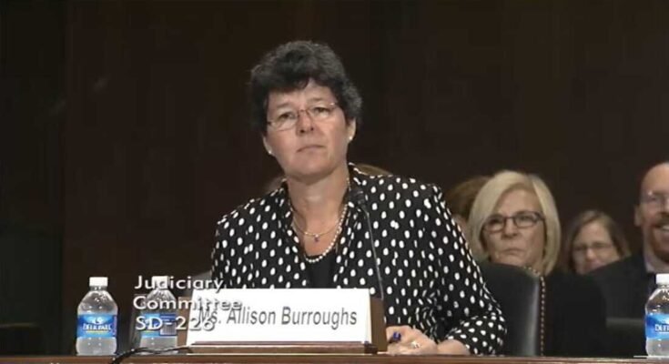 En esta captura de pantalla, Allison Burroughs se sienta en una mesa equipada con un micrófono durante su audiencia de confirmación del Senado en 2014 para convertirse en un juez de distrito estadounidense.